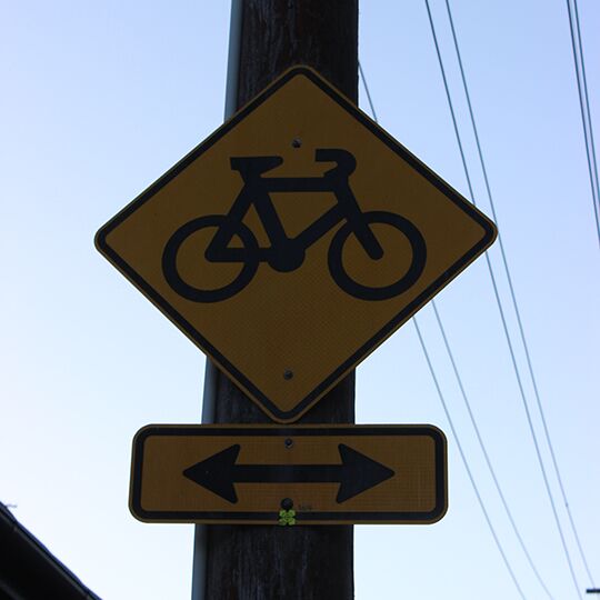 yellow diamond shaped bike sign